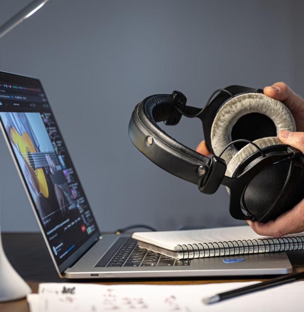 Audio on demand (AOD) : holding headphone and laptop screen showing the Audio on demand app 